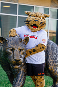 jaX the mascot standing beside the jaguar statue in front of Commons