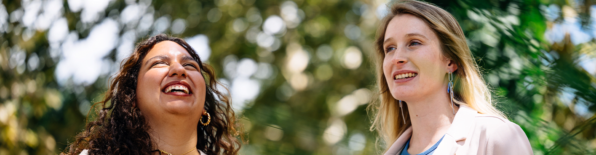 Two people standing outdoors, smiling.