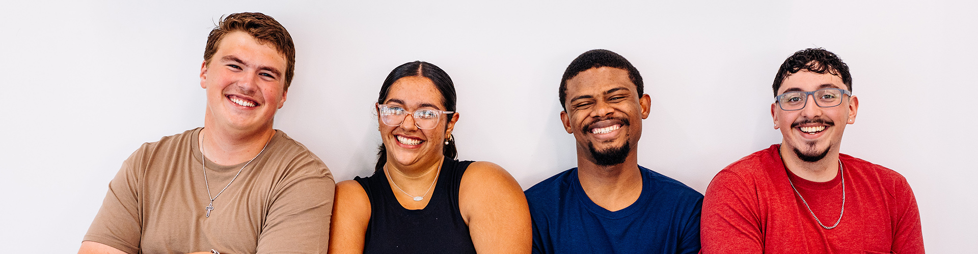 Four students smiling at the camera.