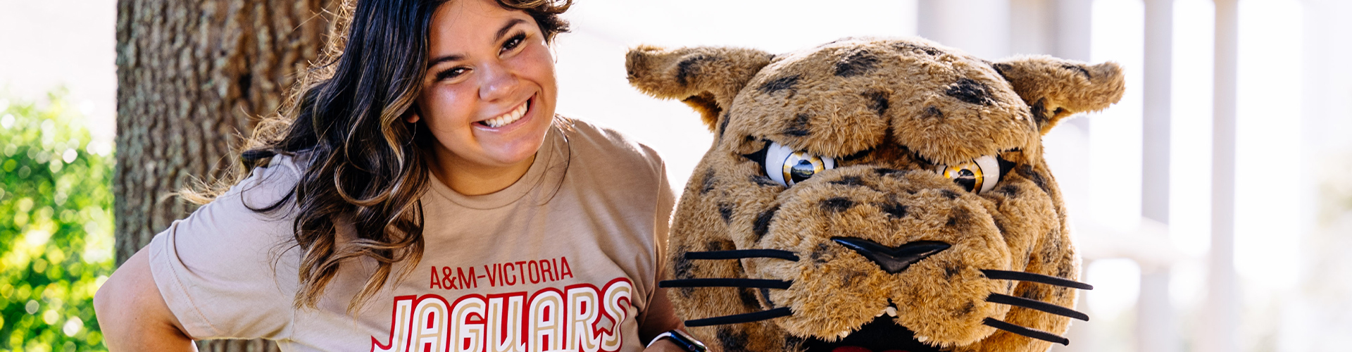 A student and Jax the mascot smiling at camera.