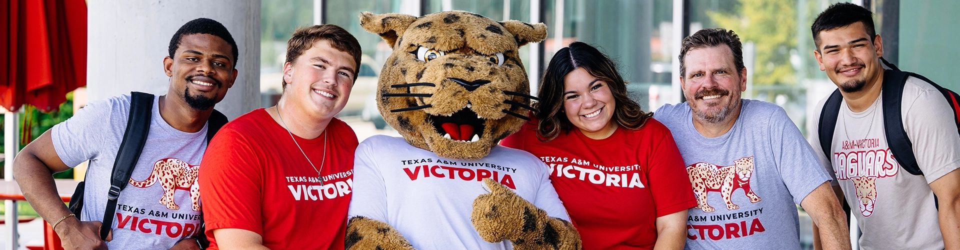 Students pose with jaX the mascot outside