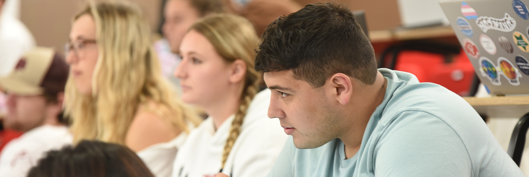 A male student sitting in class.