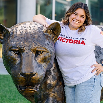 Jaguar statue and student smiling