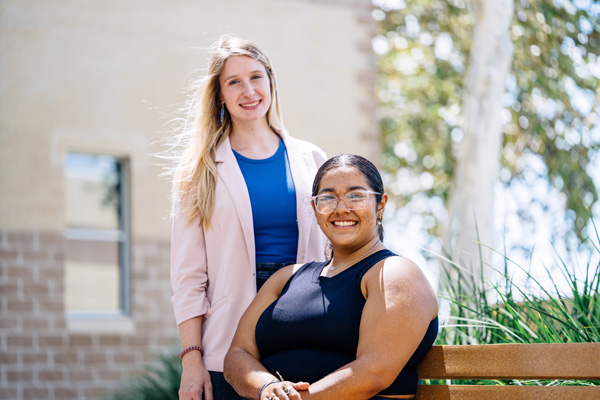 Two people near a bench outside on Texas A&M University-Victoria campus