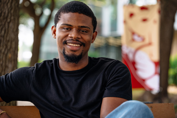 Student sitting outside on a bench on Texas A&M University-Victoria campus