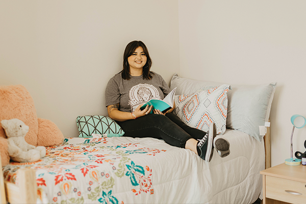 A student relaxing in her dorm room.