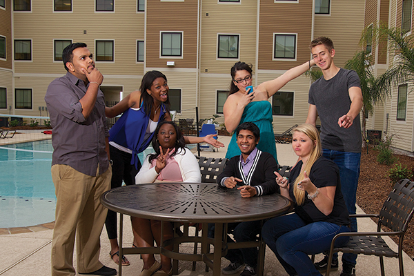 Students hanging out poolside at Jaguar Suites.