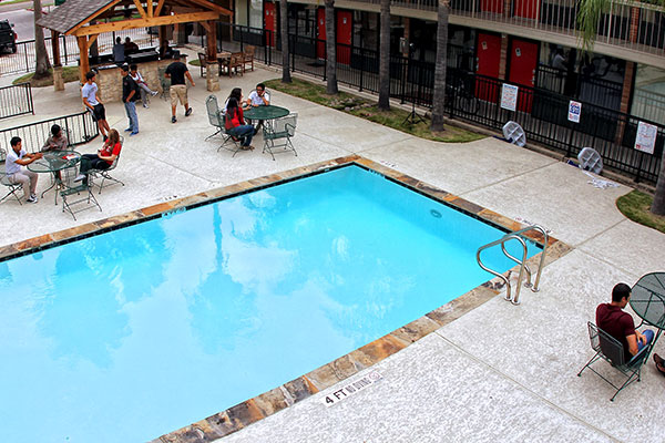 Students sitting around the pool
