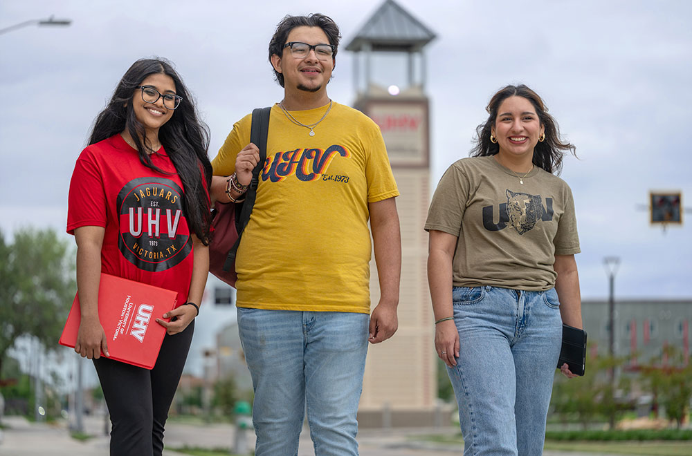 Three student on UHV campus with the UHV Tower in the background